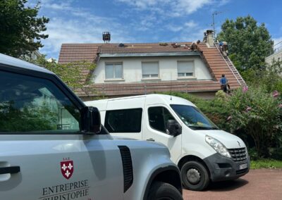 Véhicules de couvreur devant chantier de toiture à Suresnes